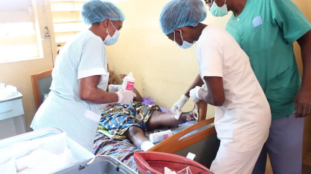 Infirmières soignant le pied d'un patient.